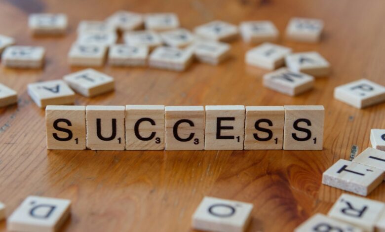scrabble tiles spelling out the word success on a wooden table