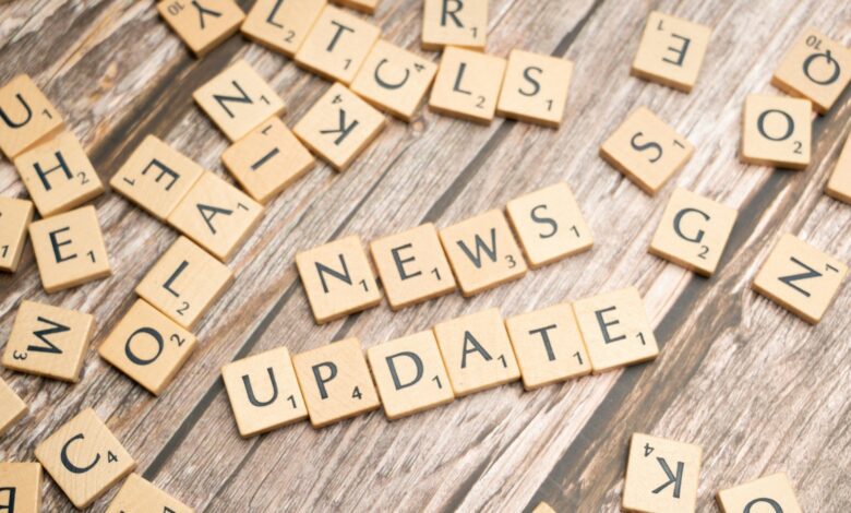 scrabble tiles spelling news update on a wooden table