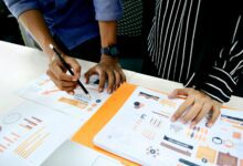 person in blue shirt writing on white paper
