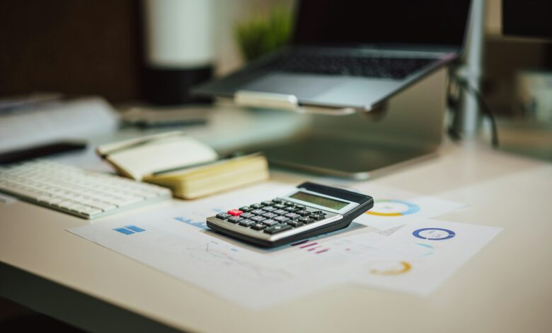 a calculator sitting on top of a table next to a laptop