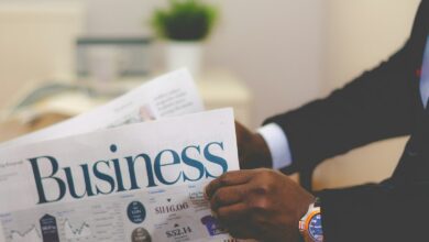 person wearing suit reading business newspaper