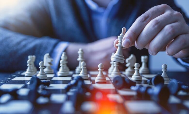 depth of field photography of man playing chess