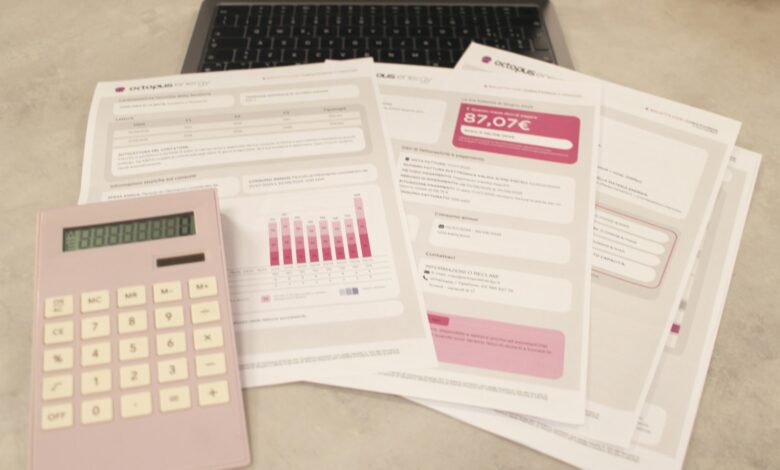 bills, calculator, and a laptop: financial tasks underway.