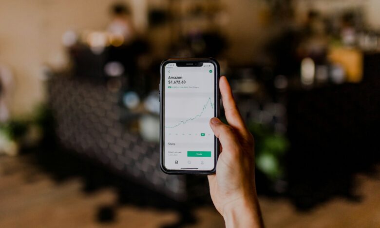 person holding black iphone displaying stock exchange