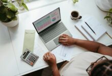 a person sitting at a table with a laptop