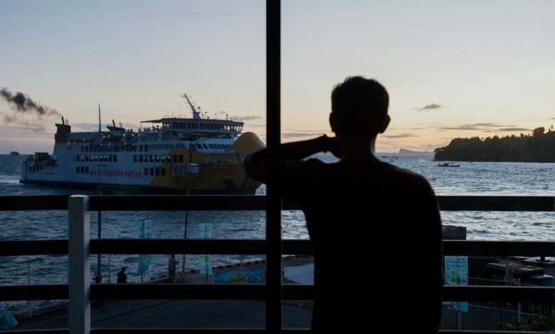 a man is looking out at a boat in the water