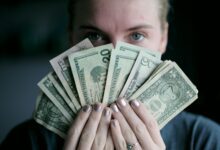 person holding fan of u.s. dollars banknote
