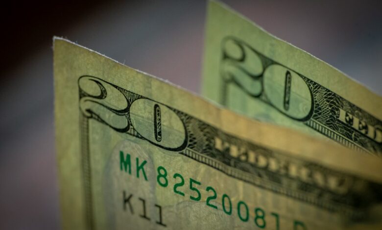 two stacks of twenty dollar bills sitting on top of each other