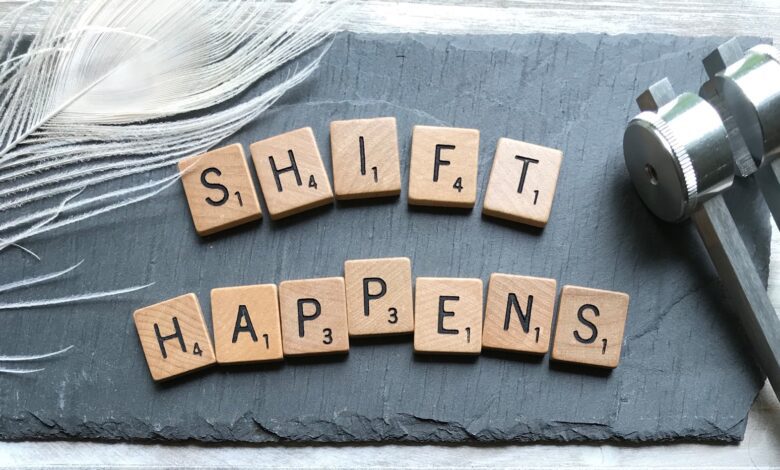 scrabble chips forming shift happens word near white feather