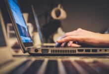 person using silver laptop computer on desk