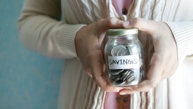 a woman holding a jar with savings written on it