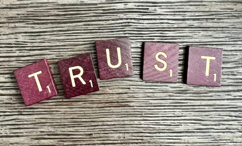 trust spelled with wooden letter blocks on a table